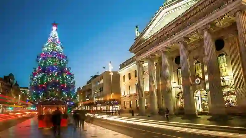 Kerstboomverlichting op O'Connell Street naast het GPO, Dublin, die 's avonds in de drukte van de stad oplicht.