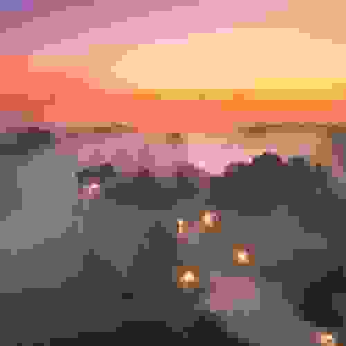 Malahide Castle, County Dublin, omgeven door mist bij zonsopgang met gloeiende lichten en een kleurrijke winterhemel.