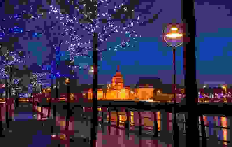  Avondzicht op het Custom House van Dublin, verlicht naast de rivier de Liffey, met feestelijke verlichting langs de kades.