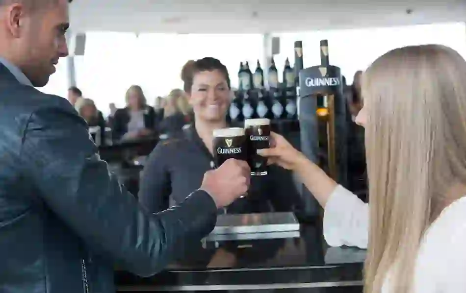 People at the Gravity bar with pints of Guinness