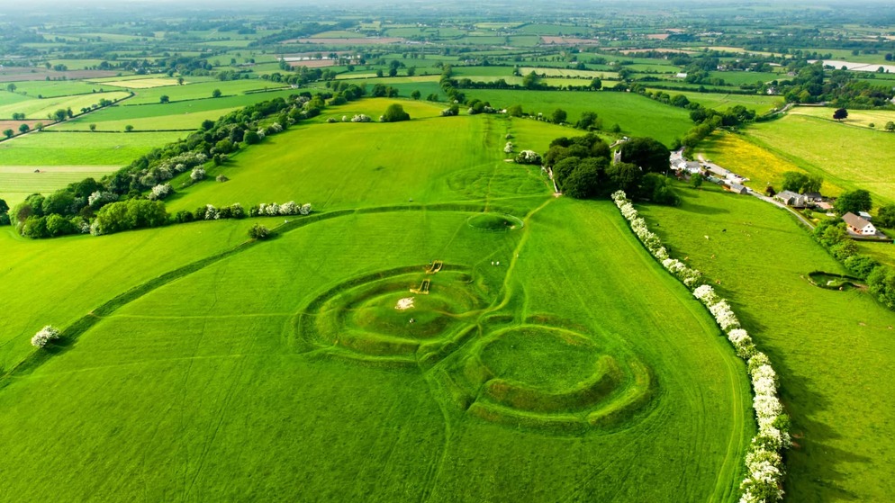 Luftbild der alten Erdwerke des Hügels von Tara, umgeben von der üppigen Landschaft von Meath unter einem klaren Himmel.