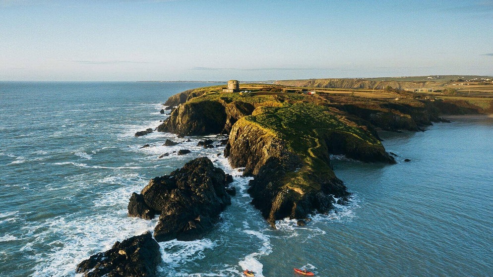 Ruig kliffen aan de kust van Wexford met een Martello-toren die uitkijkt over de Atlantische Oceaan.