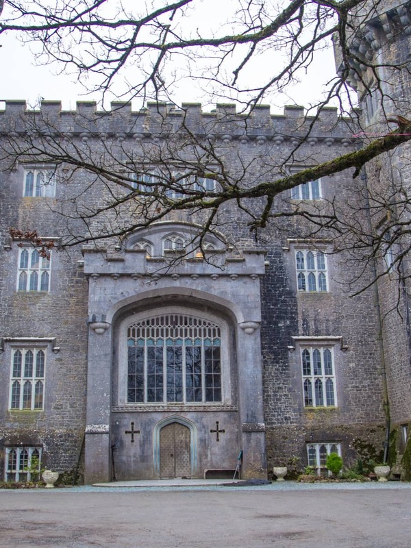 Facciata neogotica del Castello di Charleville con torri rotonde e rami spogli su uno sfondo di cielo pallido nella contea di Offaly.