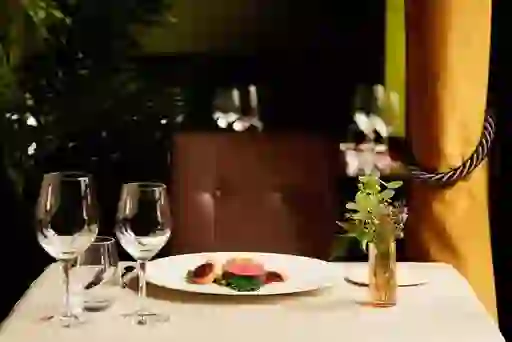 Elegante eettafel gedekt met een gastronomisch gerecht, wijnglazen en zachte verlichting in een Michelin-sterrenrestaurant in Ierland.