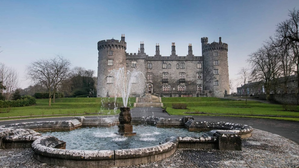 Kilkenny Castle with fountain in front, viewed from the gardens in Ireland’s Ancient East.