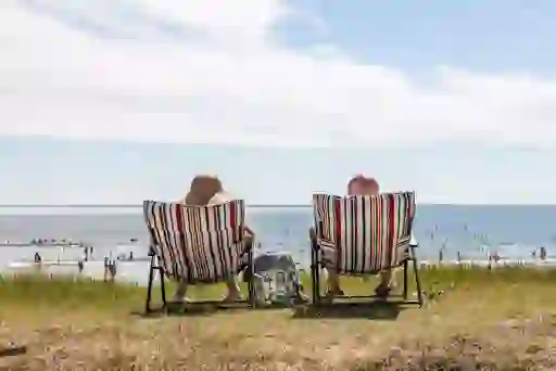 A couple sunbathe on deckchairs at the seafront in Claycastle Youghal Co Corkwebsize2500x1200px