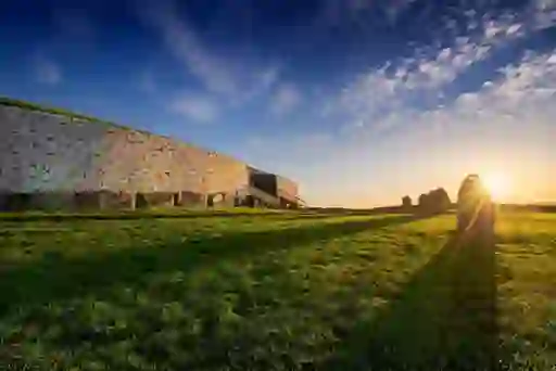 The ancient passage tomb of Newgrange in County Meath, with its white quartz stone facade and standing stones at sunset.