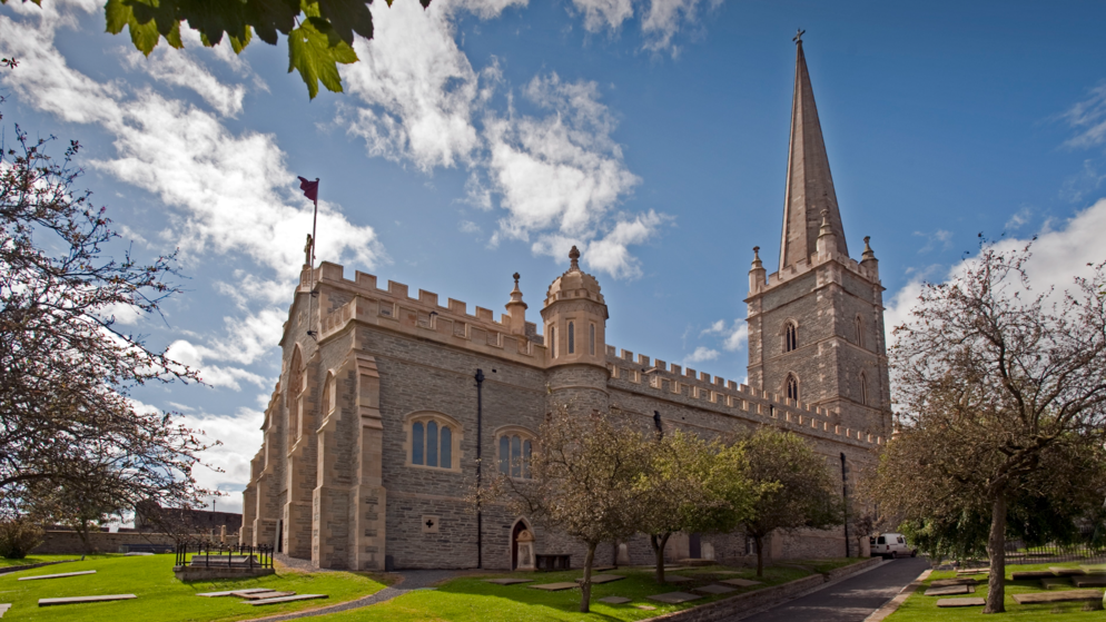 St Columb's Cathedral and its Gothic spire surrounded by historic grounds in Derry~Londonderry.
