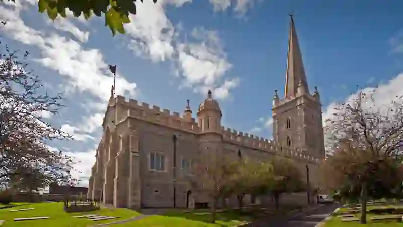 St Columb's Cathedral and its Gothic spire surrounded by historic grounds in Derry~Londonderry.