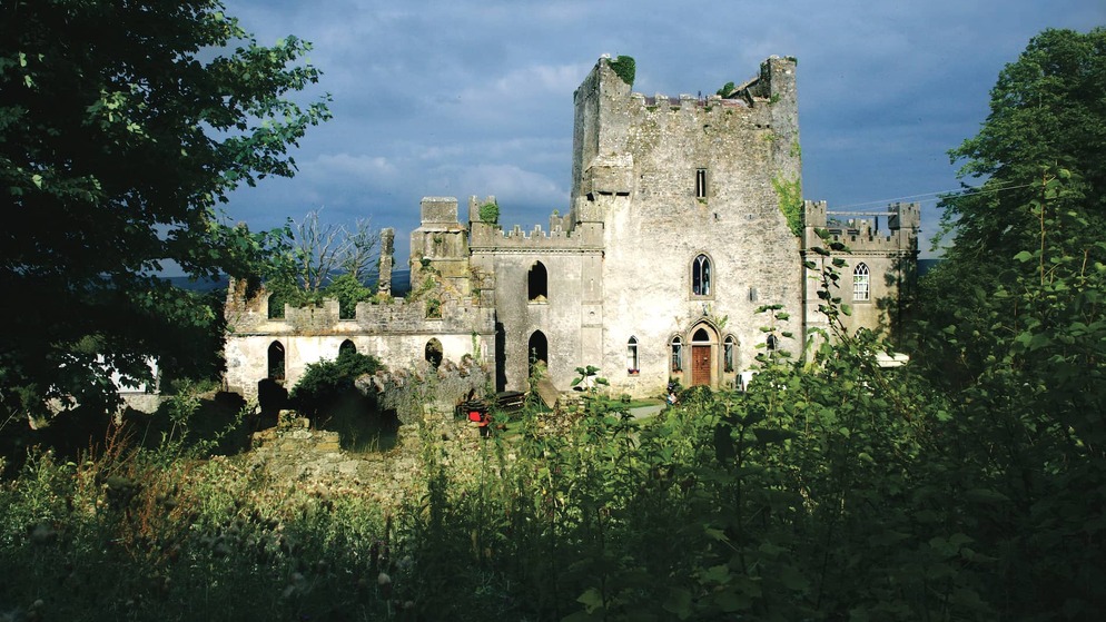 Außenansicht von Leap Castle, Irlands gruseligstem Schloss, mit efeubewachsenen Ruinen und einer dramatischen Steinfassade.