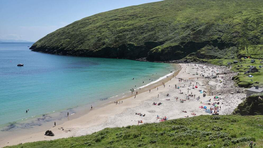 Crowds enjoying the sandy beach and turquoise waters at Keem Bay, Achill Island.