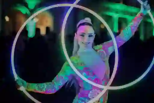 Street performers in illuminated costumes smiling at New Year's Festival in Dublin city.