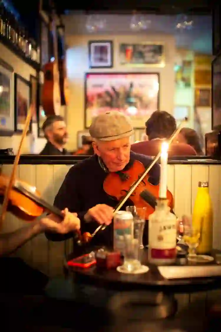 Traditional Irish fiddle player performing live inside The Sunflower pub in Belfast, Northern Ireland.