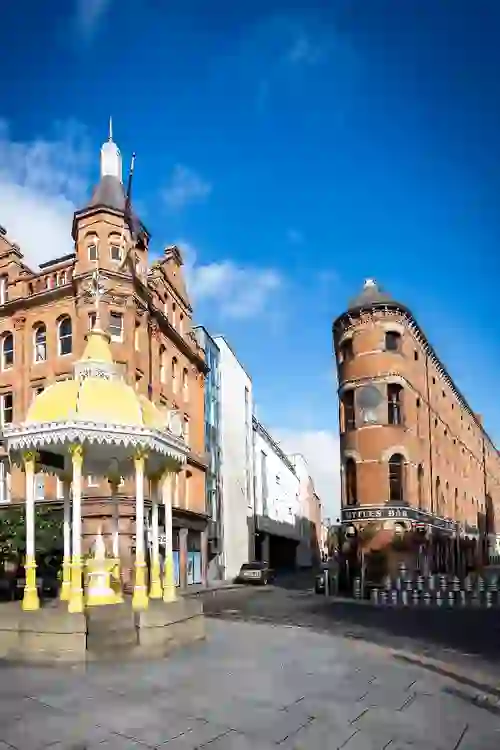 Bittles Bar in Belfast, a distinctive red-brick flatiron building beside the ornate Jaffe Memorial Fountain.
