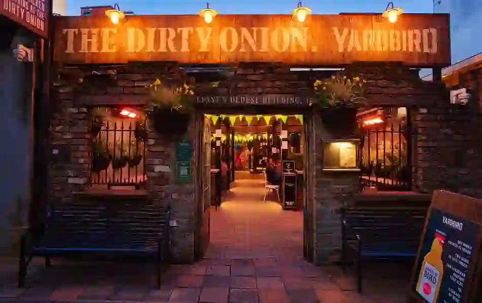 The Dirty Onion in Belfast, with its rustic brick entrance and warmly lit courtyard.