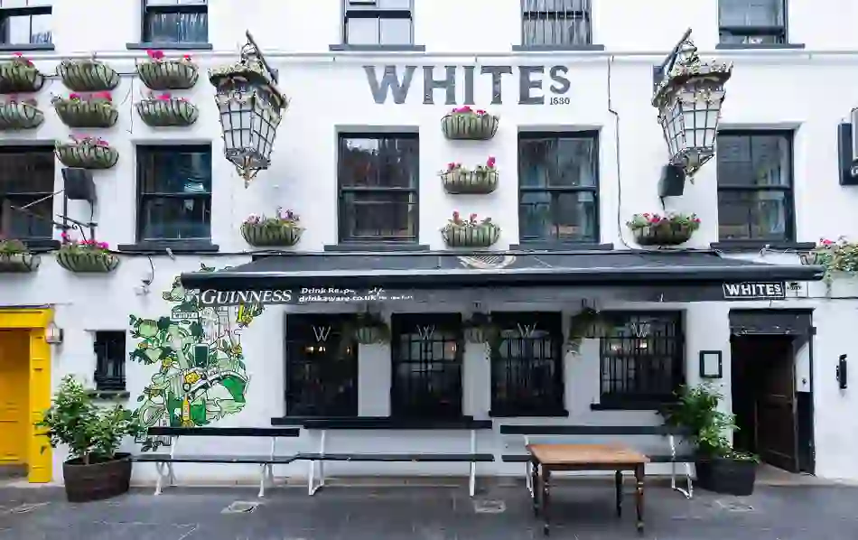 White’s Tavern in Belfast, with its white façade, hanging flower baskets and traditional pub frontage.