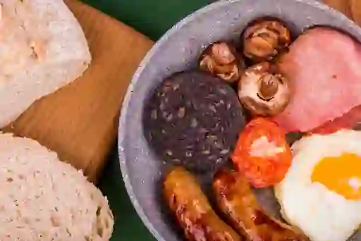Ulster fry with sausages, bacon, black pudding, mushrooms, tomato and fried egg, served with bread.