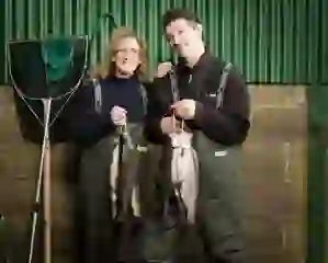 Two fish producers holding fresh trout while standing in waders at Goatsbridge Trout Farm, County Kilkenny.