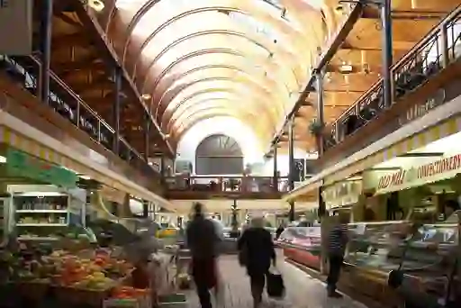 Shoppers browse fruit, vegetables, meat and other produce beneath the vaulted roof of the English Market in Cork City.