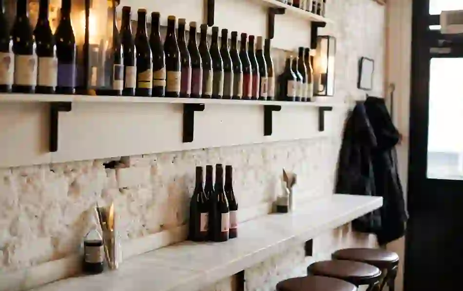 Wine bottles line shelves above a marble counter in the cosy interior of Fish Shop in Dublin.