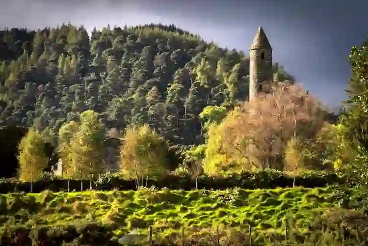 Historic Glendalough Round Tower surrounded by woodland in County Wicklow.