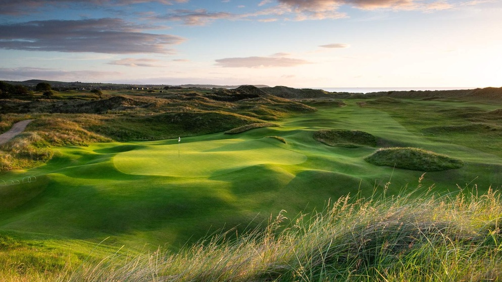 Sunset over rolling fairways at a links golf course in Ireland’s Ancient East with scenic dunes.