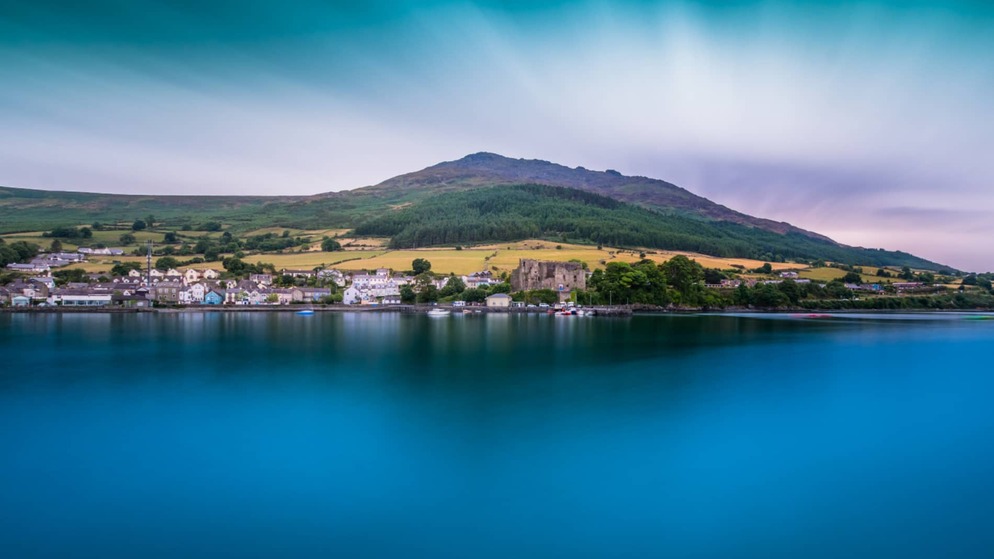 Panoramisch uitzicht op het dorp Carlingford en het kasteel van King John, met de Cooley Mountains die boven de lough uitstijgen.