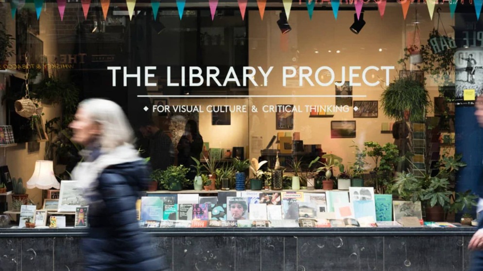 Belebter Eingang von Hodges Figgis in Dublin mit Lesern, die Bücher durchblättern; das Schild trägt die Aufschrift 'Ein Leitfaden für Dublins beste Buchläden'.