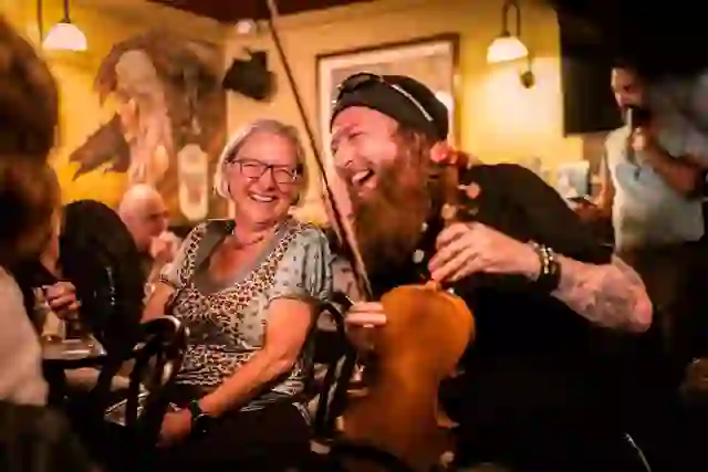 Een traditionele muzikant vermaakt de bezoekers tijdens een levendige Ierse muzieksessie in McHugh's pub in Belfast.