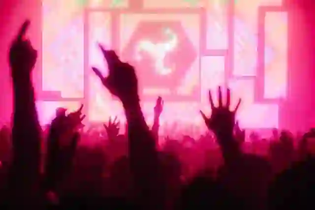 Een menigte geniet van een live optreden met elektronische muziek en kleurrijke podiumbeelden op het AVA Festival in Belfast.