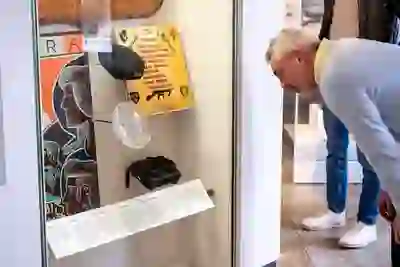 Un visitatore si china per osservare i reperti e i documenti in mostra in una teca espositivadell'Ulster Museum a Belfast.