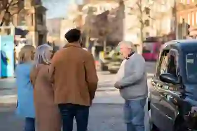 Una guida locale parla con i visitatori durante un Black Taxi Tour in una via di Belfast.