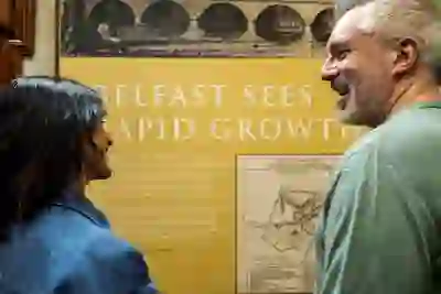 Due visitatori leggono un pannello espositivo sull'espansione di Belfast all'interno della City Hall.