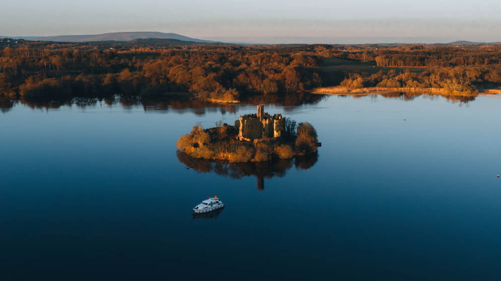 Aerial view of McDermott’s Castle on a small island in Lough Key, County Roscommon, at sunset.