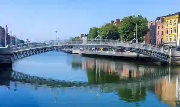 The Ha’penny Bridge spanning the River Liffey on a bright day in Dublin city centre.