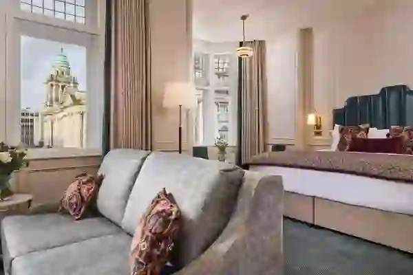 Een elegante hotelkamer in The Bedford Hotel Belfast, met uitzicht op het stadhuis van Belfast vanuit het raam.
