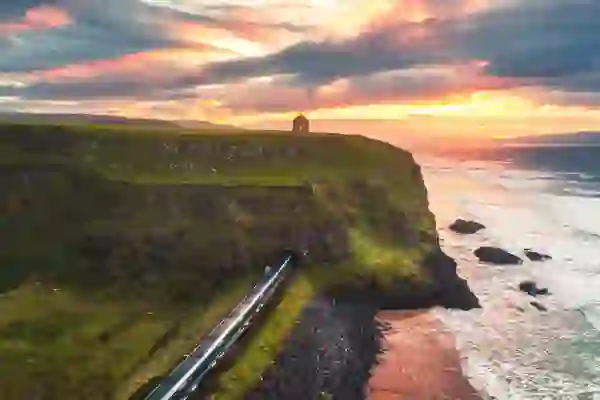 Een trein die bij zonsondergang onder de Mussenden Temple tevoorschijn komt, naast Downhill Strand, county Londonderry.