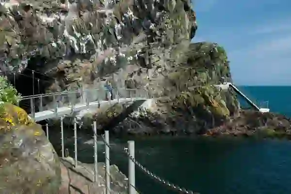Bezoekers die over het klifpad van The Gobbins boven de zee lopen, county Antrim.