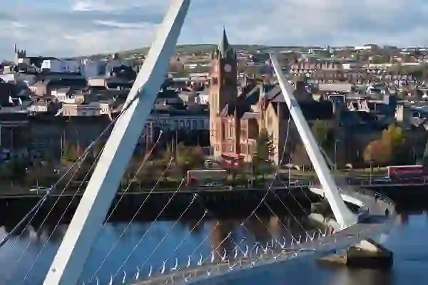 De skyline van Derry~Londonderry, omlijst door de Peace Bridge die de rivier de Foyle overspant.