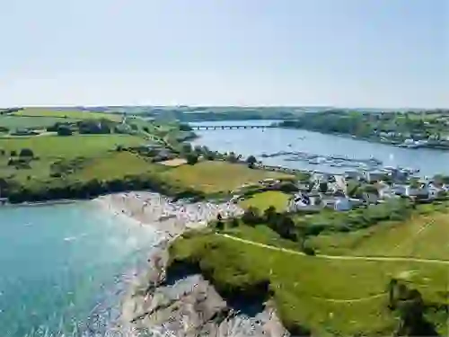 Aerial view of Kinsale Harbour with sandy beach, marina and surrounding countryside in County Cork.