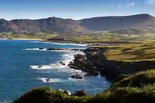 Coastal landscape of the Beara Peninsula with town of Allihies and Slieve Miskish Mountains in background.