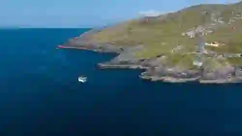 Dursey Island cable car station on the Beara Peninsula with a boat on the Atlantic below.