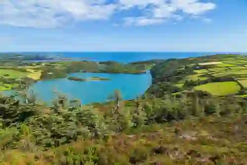Scenic view over Lough Hyne nature reserve with woodland, islands and the Atlantic Ocean beyond. 