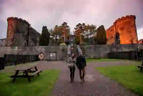 Visitors walking through the courtyard of Cork City Gaol historic prison at sunset.