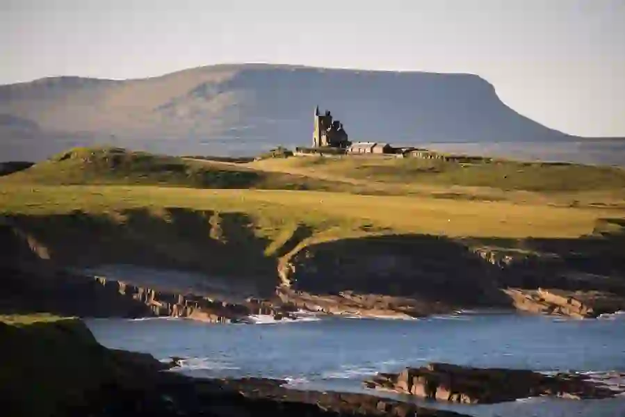 Classiebawn Castle op een groene kaap met uitzicht op de zee en Ben Bulben op de achtergrond, county Sligo.