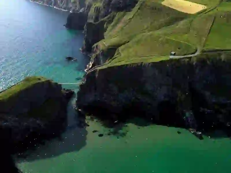Luchtfoto van de Carrick-a-Rede Rope Bridge over de kliffen en het turquoise water in county Antrim.