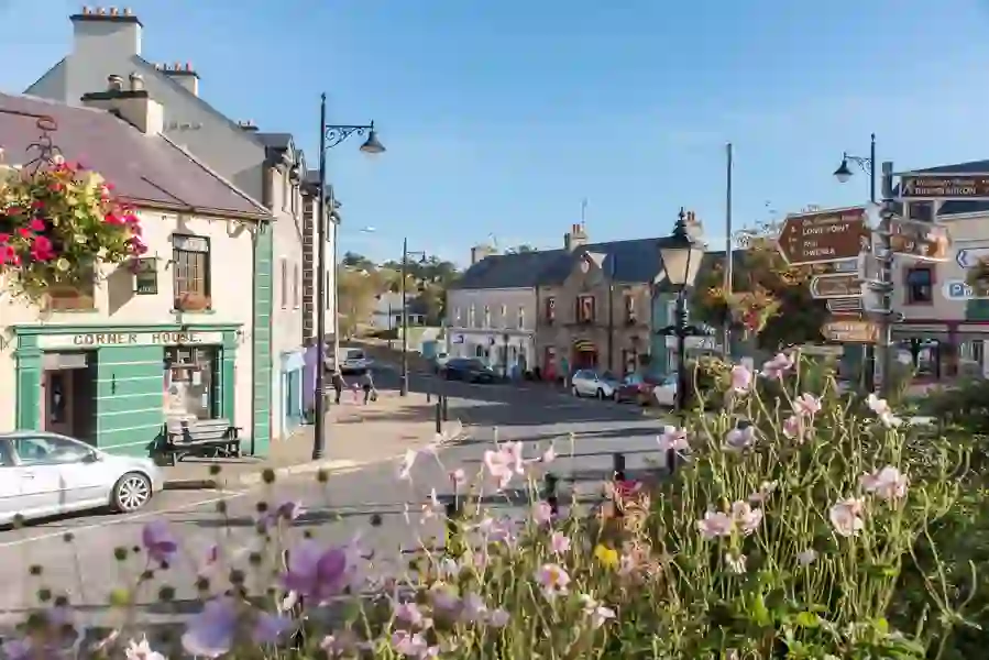 Charmante straat in Ardara, county Donegal, met hangende bloembakken en traditionele Ierse winkelpuien.