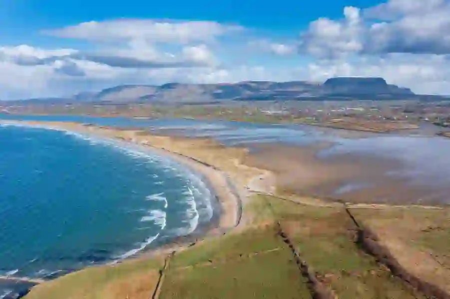 Luchtfoto van Streedagh Beach, dat langs de Atlantische kust kronkelt met de Ben Bulben berg op de achtergrond, county Sligo
