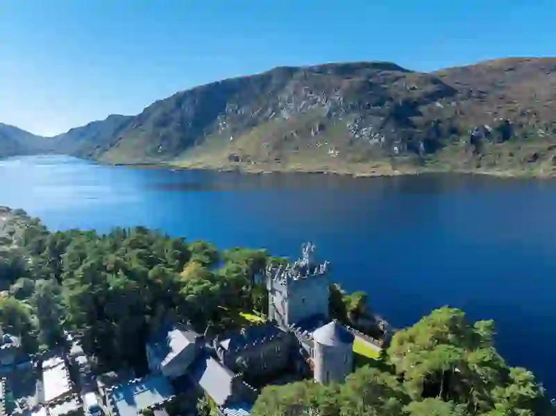 Glenveagh Castle bij Lough Veagh, omgeven door bomen en bergen in GlenveaghNational Park, county Donegal.