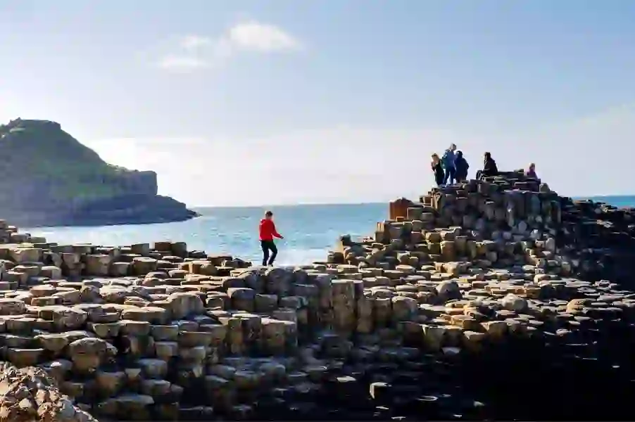 Toeristen verkennen de basaltzuilen bij de Giant's Causeway langs de kust van Antrim.